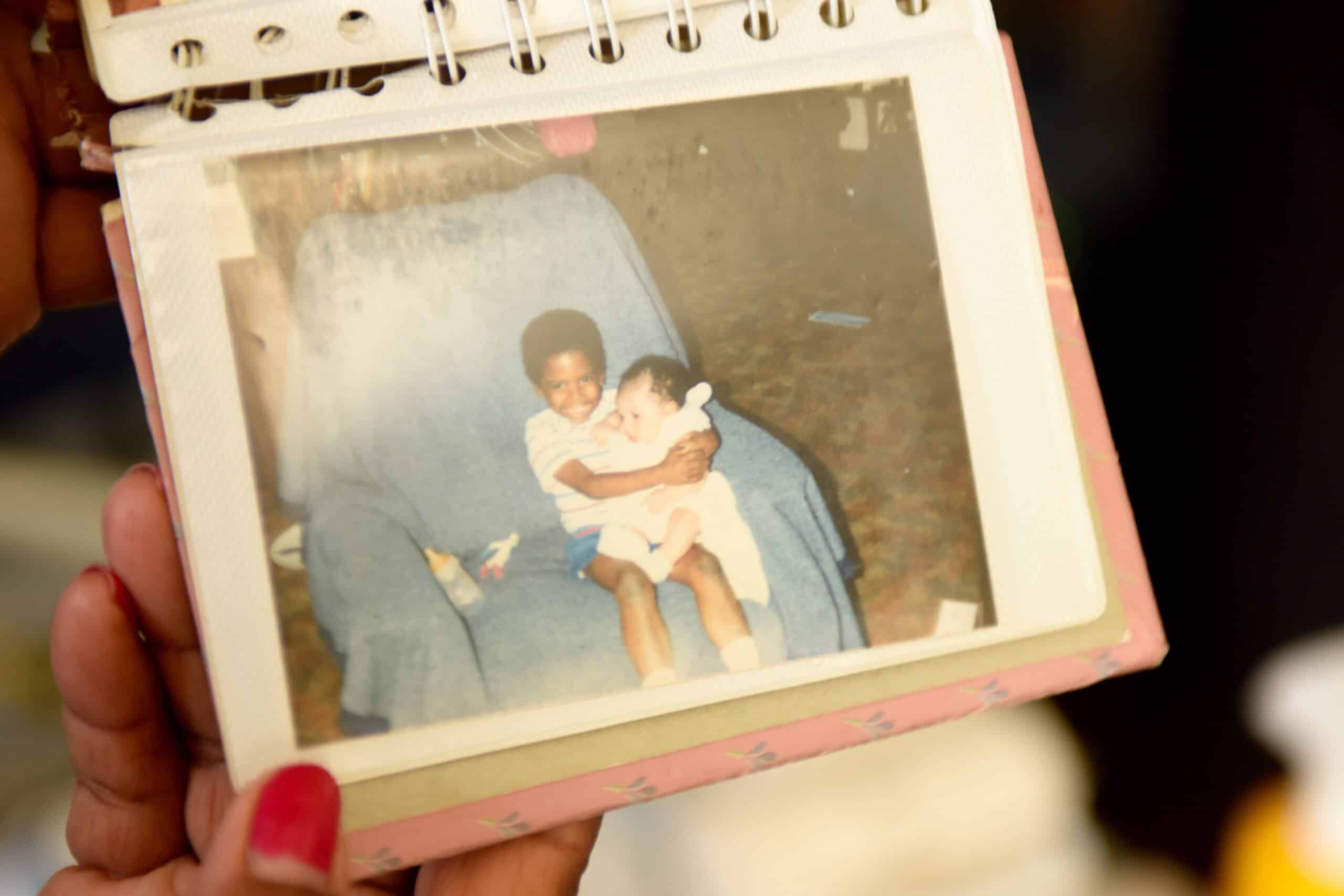 Young Marqus holding Ashley on a blue chair